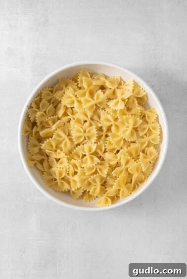 Farfalle Fiesta Salad 11 a white bowl filled with pasta on top of a table.