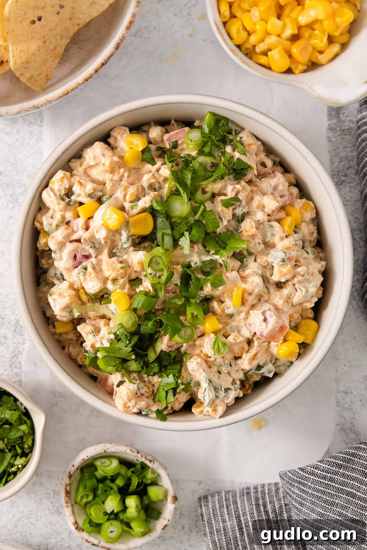 Ultimate Cream Cheese Corn Dip 2 A vibrant bowl of creamy corn dip, garnished with fresh cilantro, ready to be served with chips.