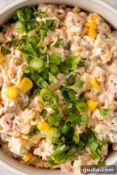 Ultimate Cream Cheese Corn Dip 13 A white bowl filled with a finished corn dip, ready to be chilled.
