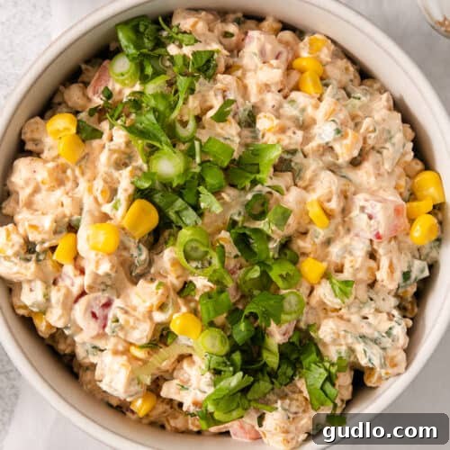 A white bowl filled with a mixture of food, showcasing the finished corn dip.