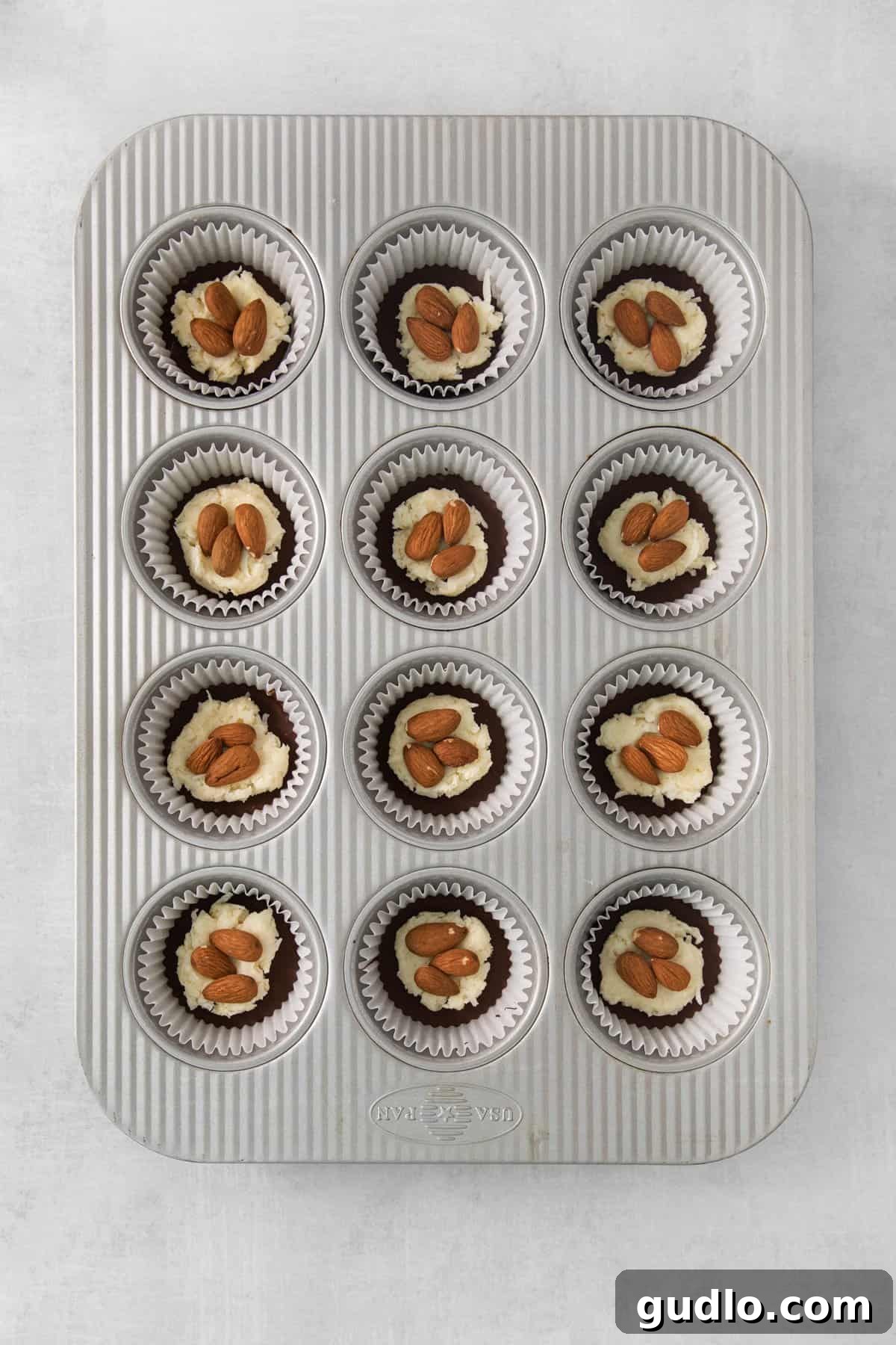 DIY Almond Joys 6 A muffin tin with twelve small, perfectly formed chocolate and coconut candies, ready for their final coating.
