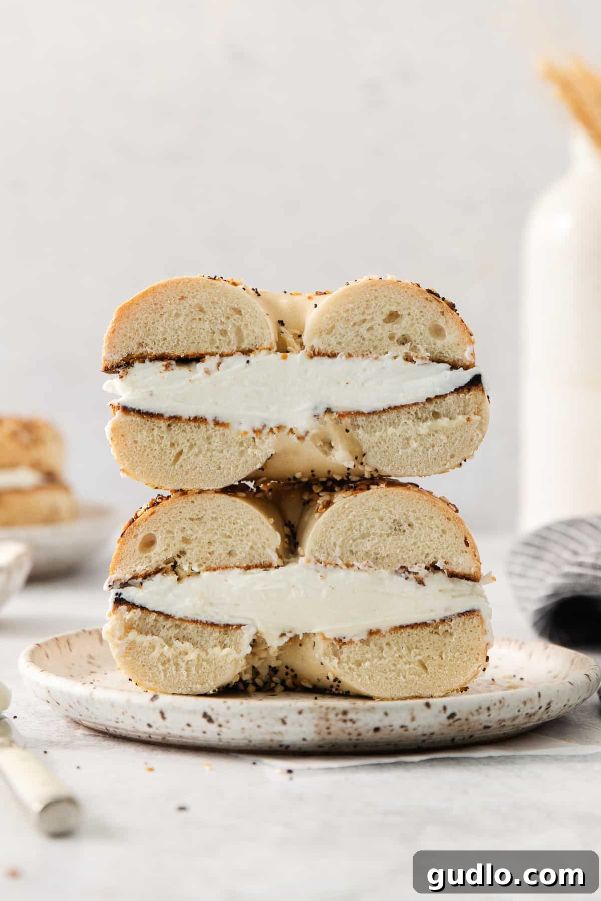 A delectable stack of bagel sandwiches generously topped with homemade cream cheese, promising a delightful breakfast.