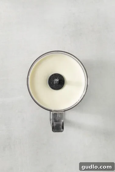 A close-up of a white candle with a black lid, symbolizing the smooth, blended cottage cheese base.