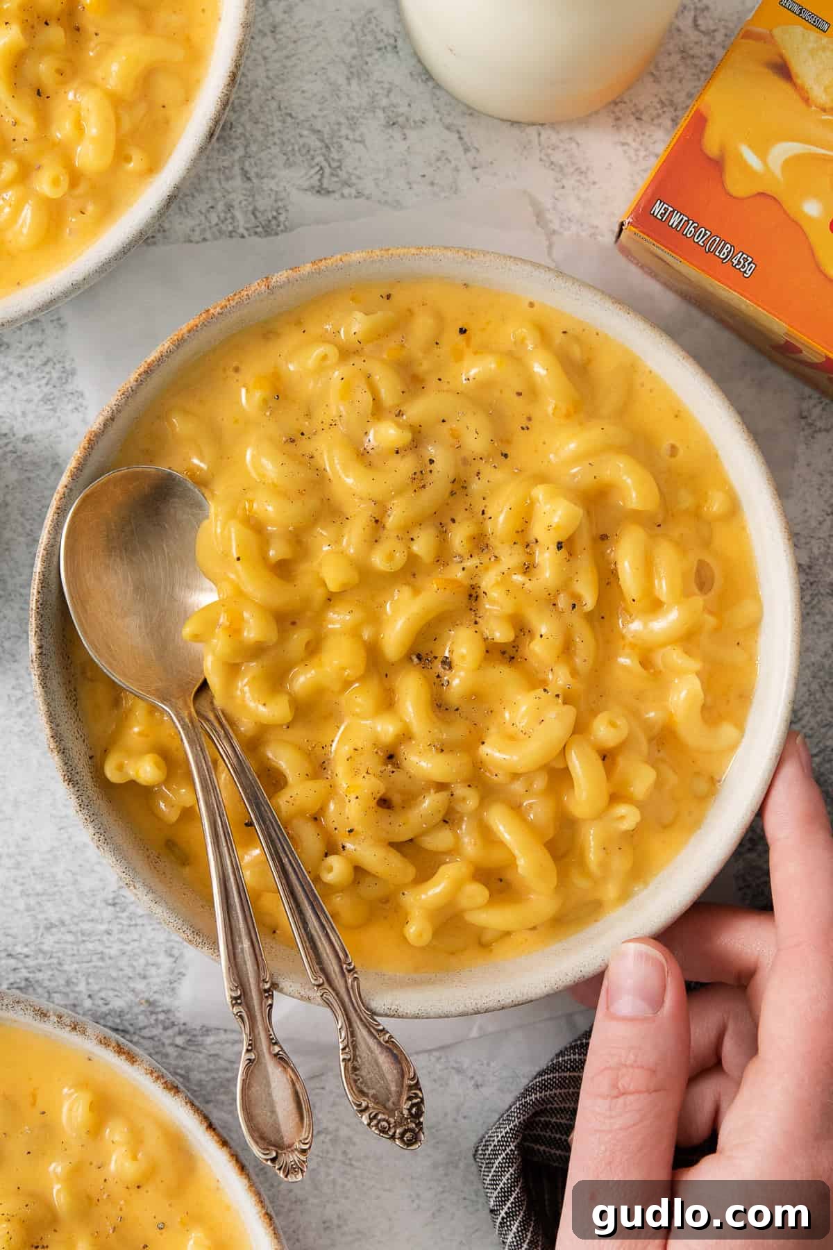 Ultimate Velveeta Crockpot Mac and Cheese 8 a person holding a bowl of macaroni and cheese.