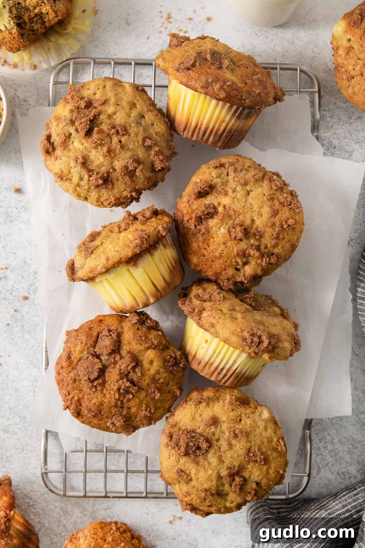Decadent Cream Cheese Banana Bread Muffins 2 Freshly baked cream cheese banana bread muffins cooling on a wire rack, showcasing their golden-brown tops and moist texture.