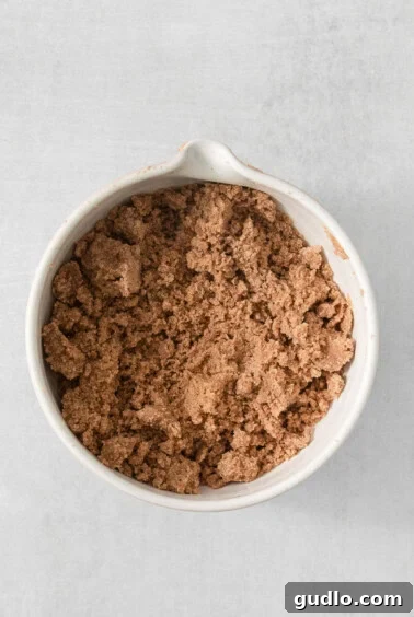 Decadent Cream Cheese Banana Bread Muffins 12 Crumble topping ingredients mixed in a white bowl on a white background.