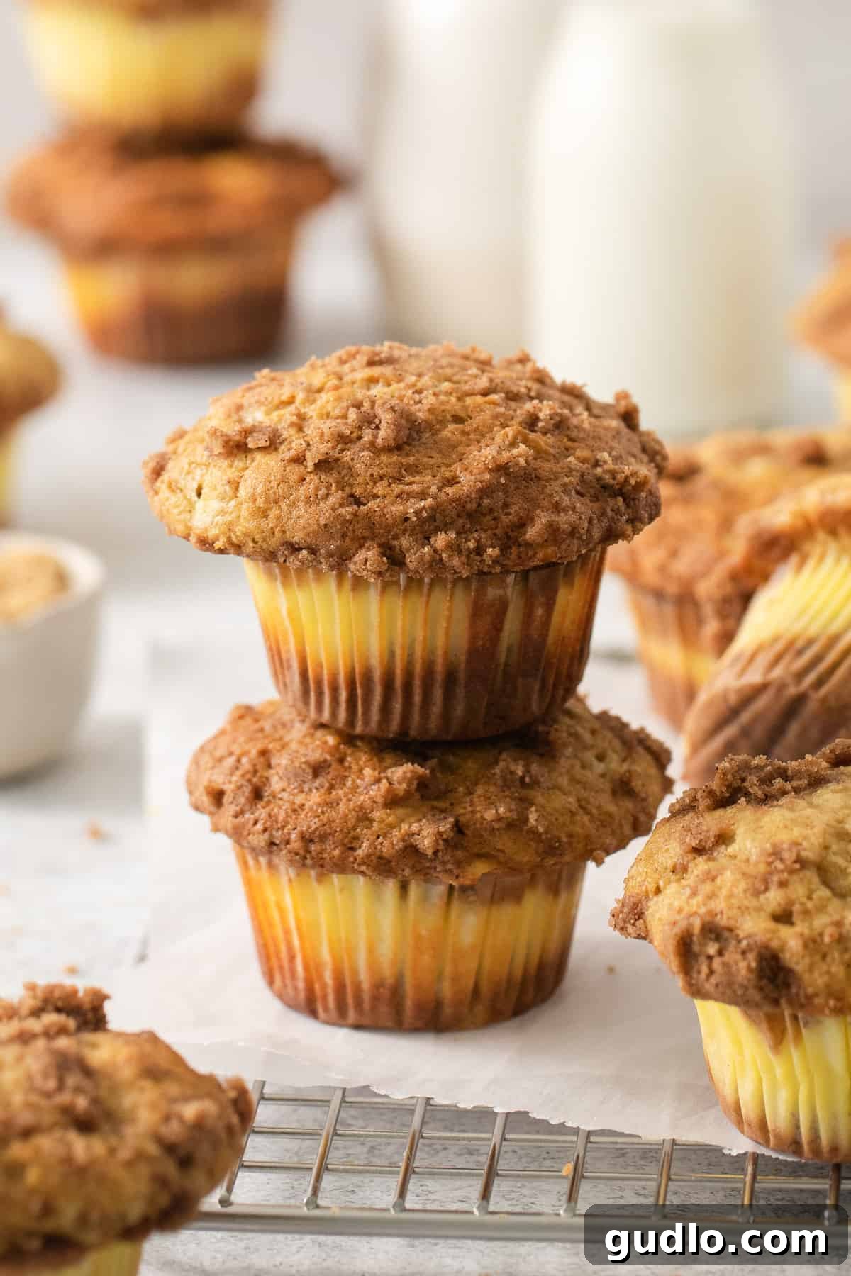Decadent Cream Cheese Banana Bread Muffins 6 A beautiful stack of cream cheese banana bread muffins on a cooling rack, showcasing their fluffy texture and enticing topping.