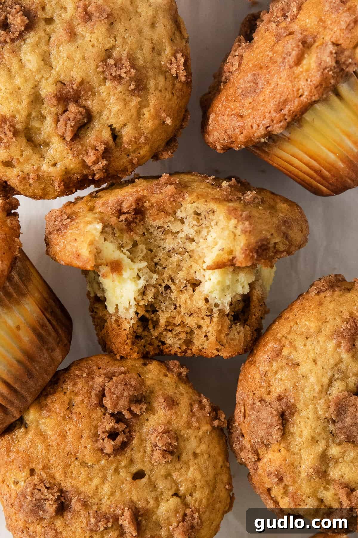 Decadent Cream Cheese Banana Bread Muffins 7 A delicious cream cheese banana bread muffin with a bite taken out, revealing the creamy center.