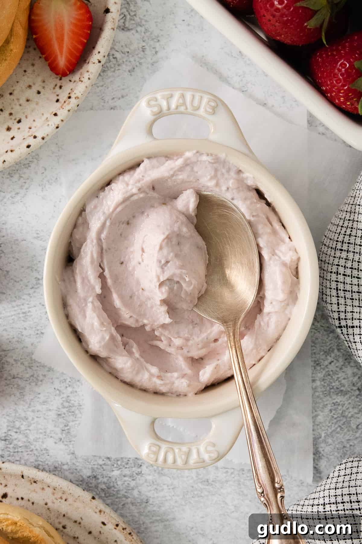 A beautifully presented bowl of homemade strawberry whipped cream cheese, ready to be enjoyed with a spoon.