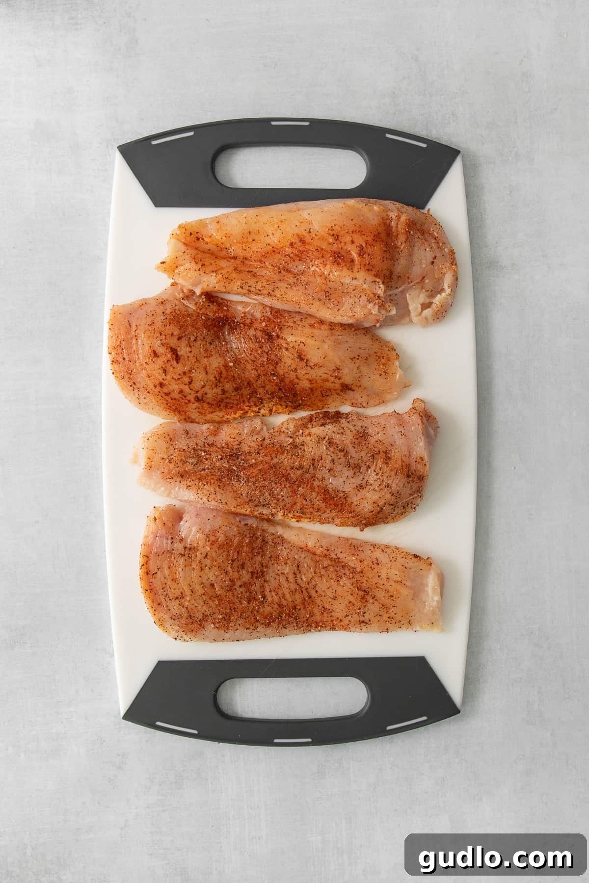 Crispy Garlic Chicken Delight 4 Golden-brown, pan-fried chicken fillets resting on a wooden cutting board, perfectly cooked and ready to be sauced.