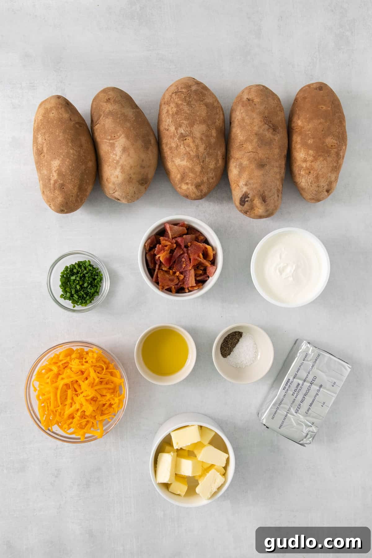 Ultimate Loaded Potato Bake 3 Ingredients for creamy mashed potatoes including Russet potatoes, butter, cream cheese, and heavy cream on a rustic wooden table.