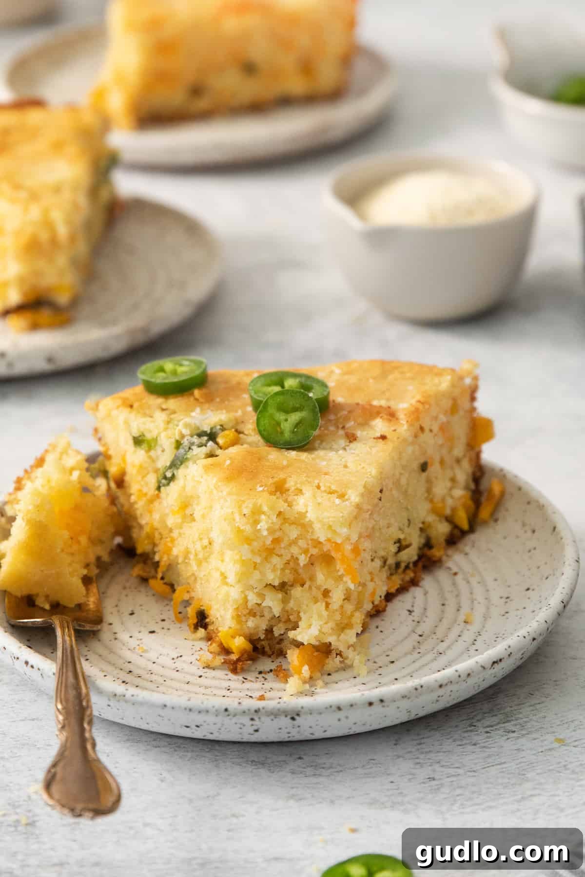 Kickin' Jalapeño Cheddar Cornbread 4 a slice of cornbread with jalapenos on a plate.