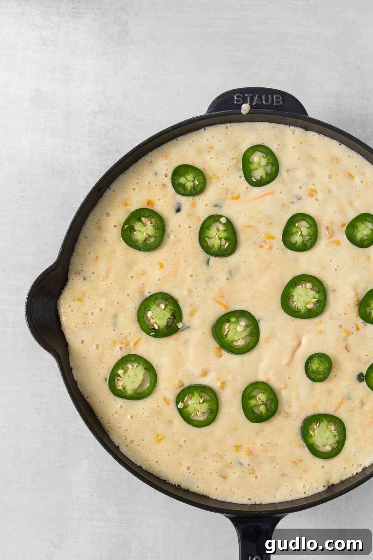 Kickin' Jalapeño Cheddar Cornbread 5 jalapeño cheese dip in a skillet with jalapeños, possibly topping cornbread.