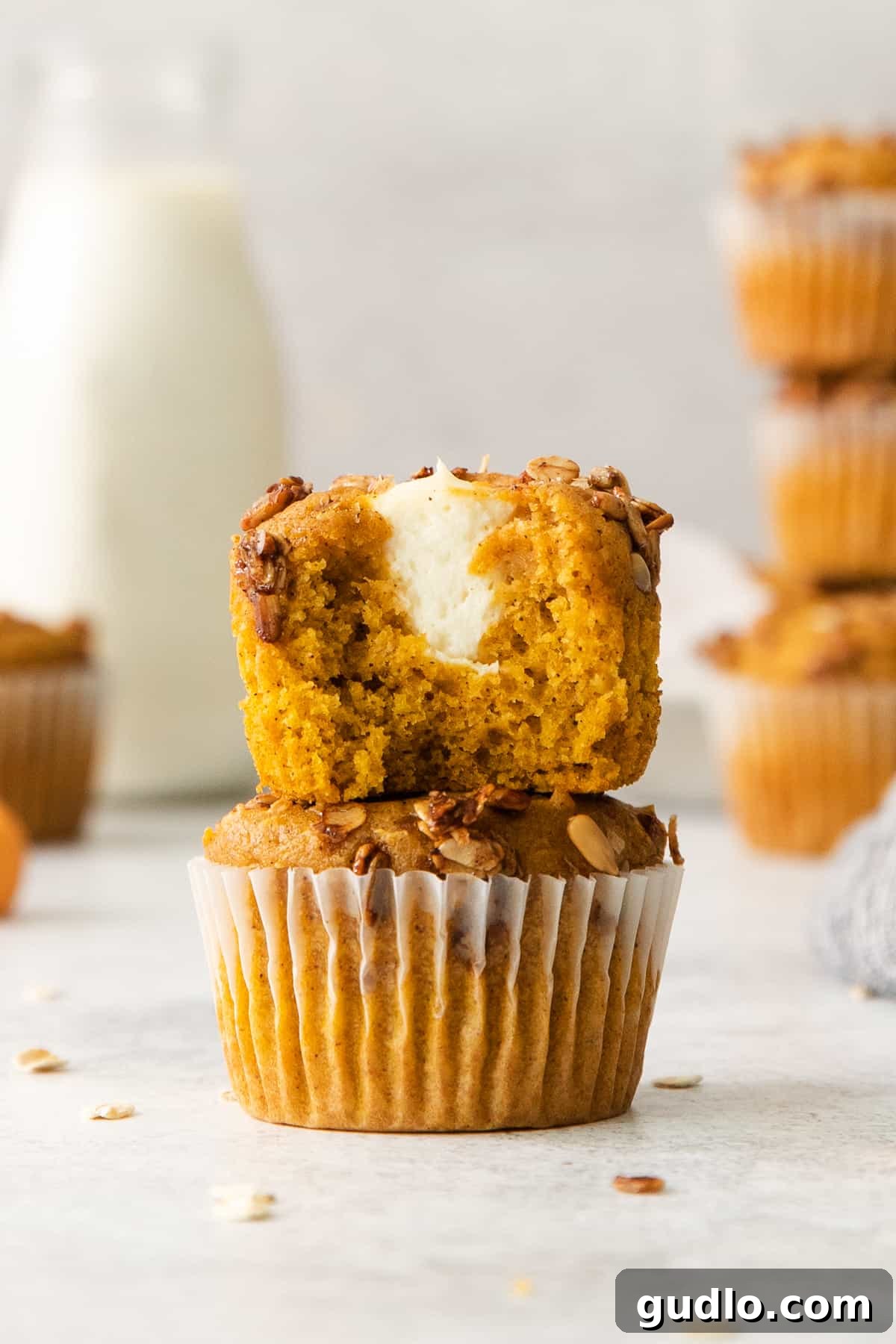 Cream Cheese Swirl Pumpkin Muffins 6 A perfectly baked pumpkin muffin with a bite taken out, revealing the soft interior and the delicious cream cheese filling.