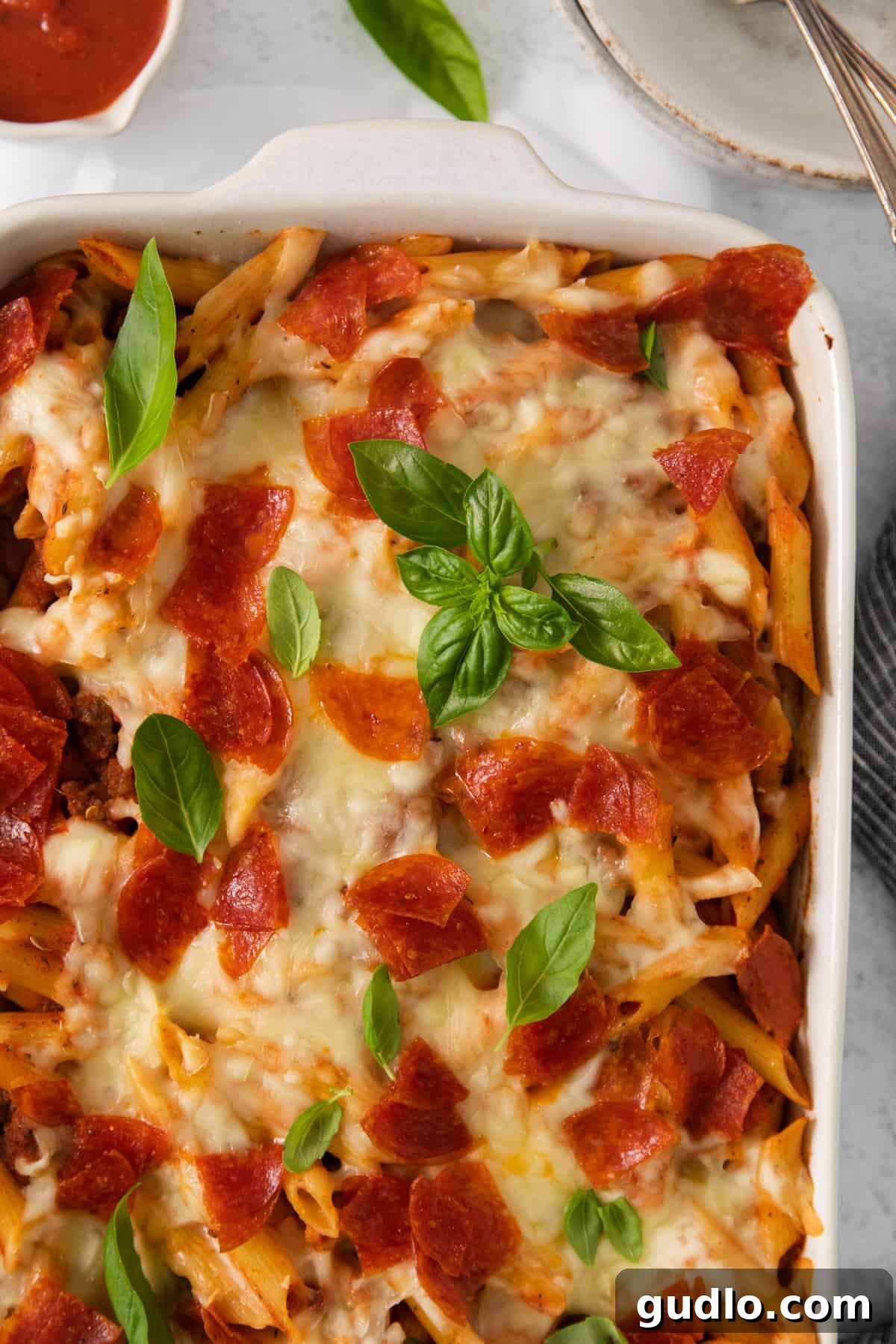 A vibrant casserole dish brimming with pepperoni, melted cheese, and pasta, ready to be served.