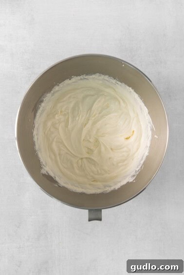 Decadent Banana Cream Cheese Pudding 12 A bowl of fluffy cream cheese whipped cream, freshly prepared and ready for use in the pudding.