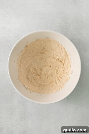 a white bowl filled with batter on top of a table.