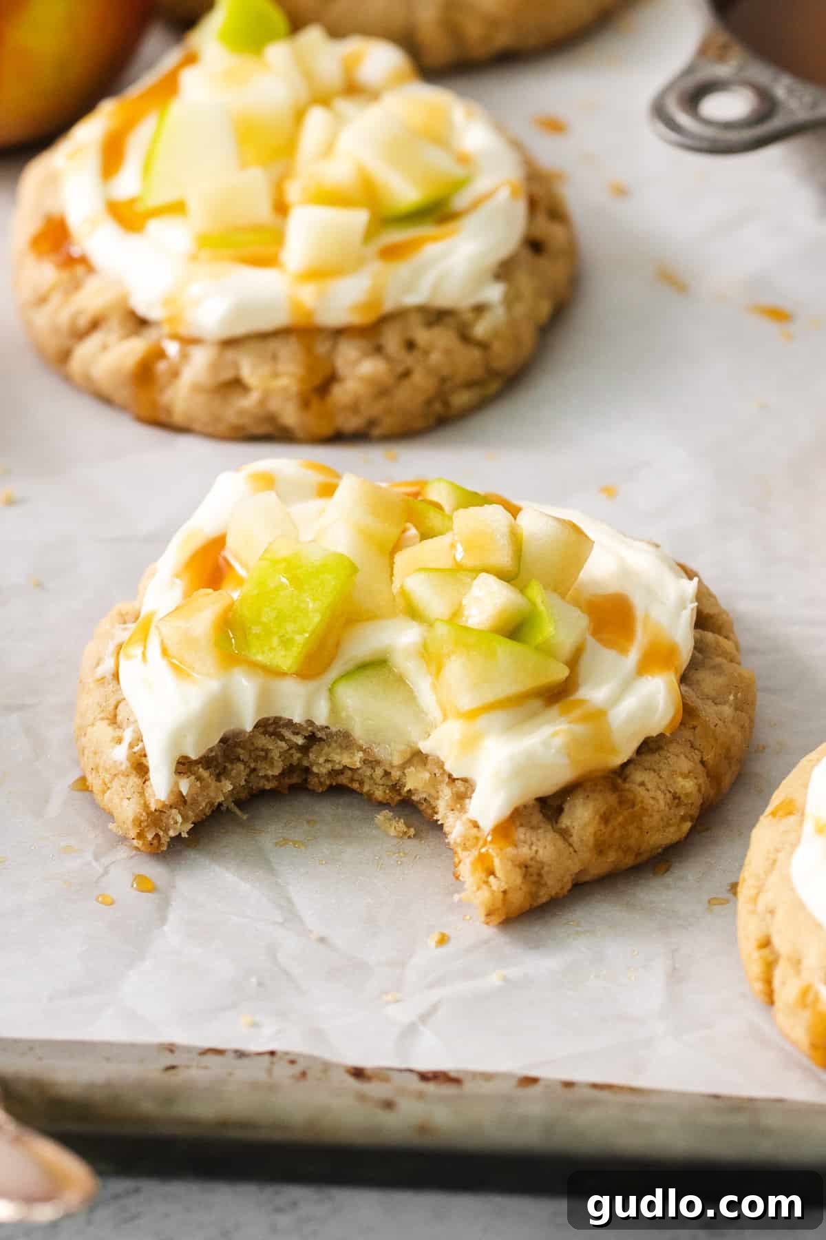 Caramel Apple Cheesecake Cookies 2 A delicious cream cheese caramel apple cookie with a bite taken out, showing its soft interior.