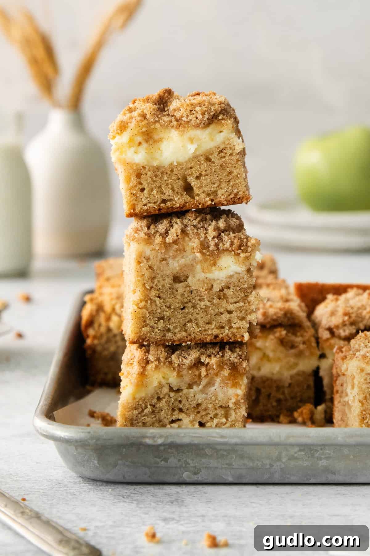 Swirled Apple Cream Cheese Coffee Cake 7 A whole Apple Cream Cheese Coffee Cake with streusel topping, ready to be cut, in a square baking dish.