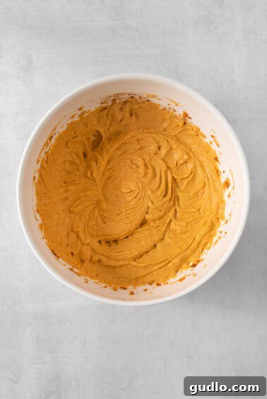 A bowl containing the blended pumpkin mousse mixture, showcasing its smooth texture before the addition of cream.