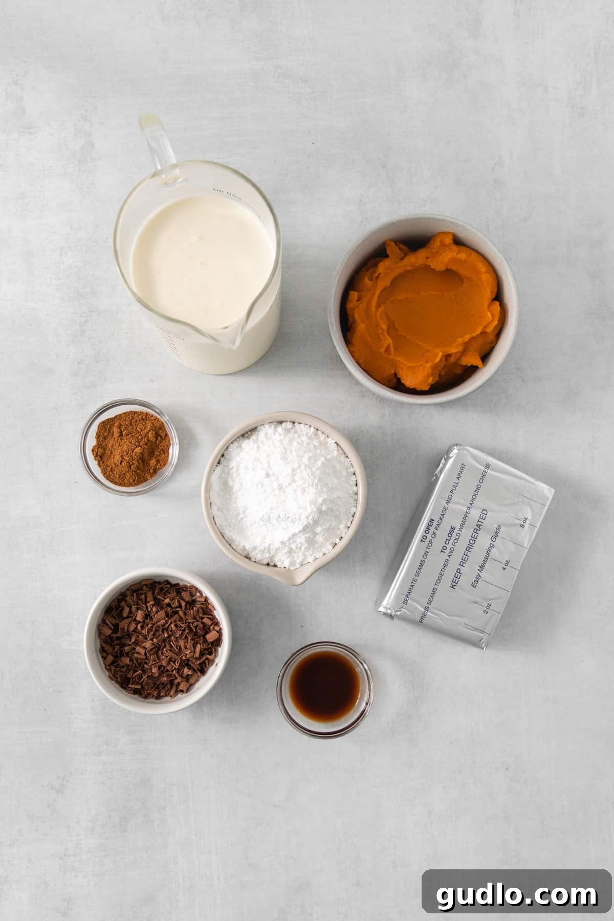 A collection of the essential ingredients for pumpkin mousse, beautifully arranged on a rustic wooden table, highlighting the fresh cream, pumpkin puree, and warm spices.