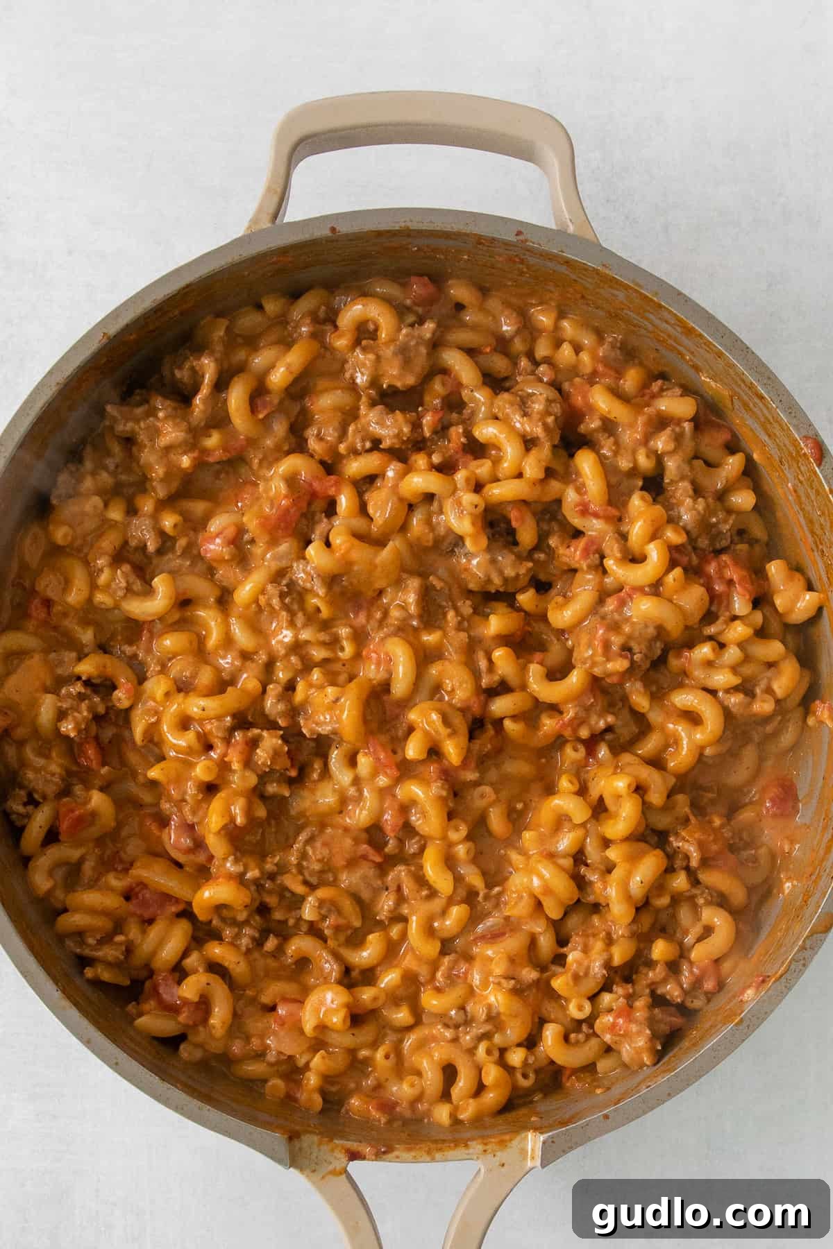 Ultimate Chili Mac and Cheese 4 Close-up of creamy macaroni and cheese with chili, bubbling invitingly in a cast-iron skillet.