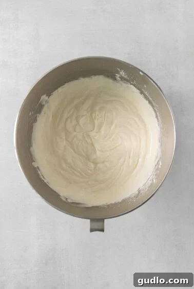 Divine Chocolate Cloud Pie 10 A bowl of freshly whipped heavy cream mixed with cream cheese, powdered sugar, and vanilla extract, showing stiff peaks.