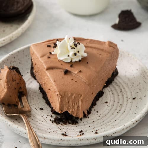 Divine Chocolate Cloud Pie 7 A beautifully presented piece of chocolate cake on a plate with a fork, tempting to eat.