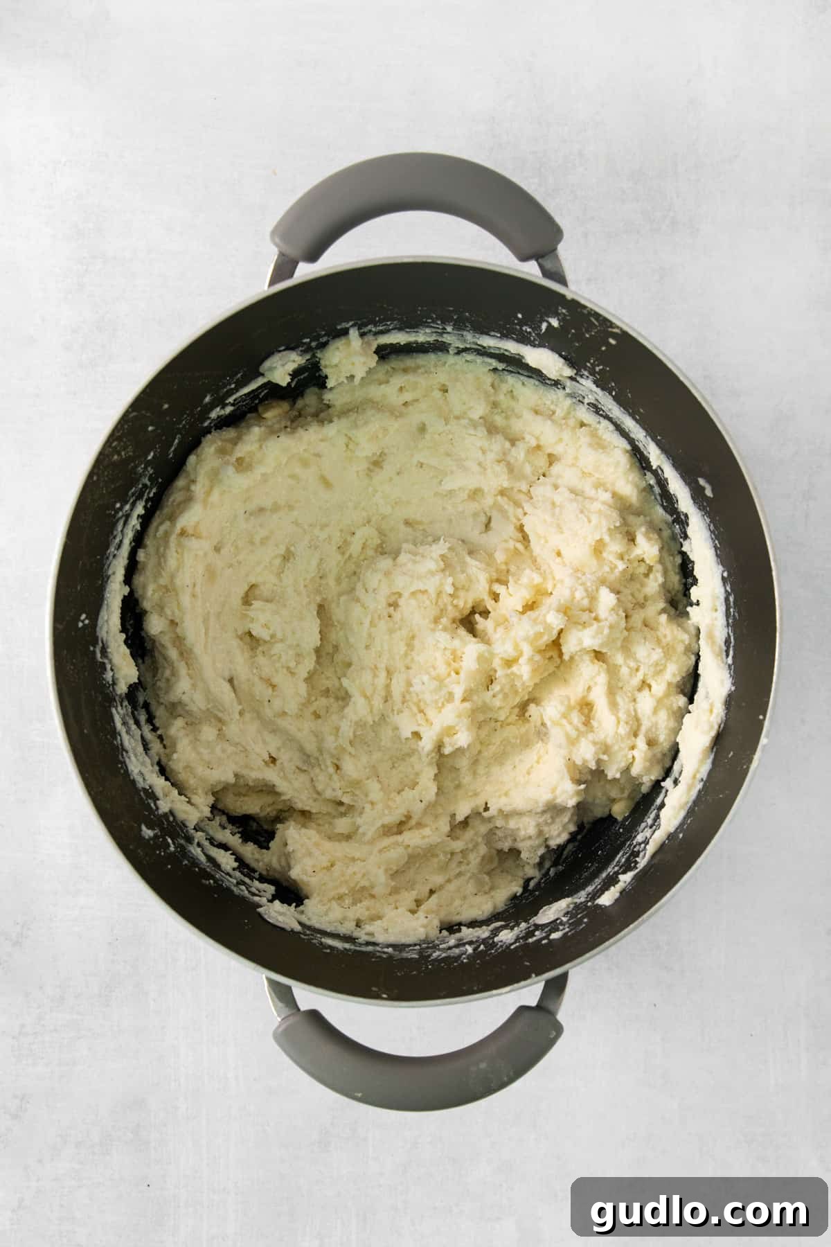 Luxurious Garlic Mashed Potatoes 5 Close-up of freshly mashed potatoes in a pan, ready to be served.