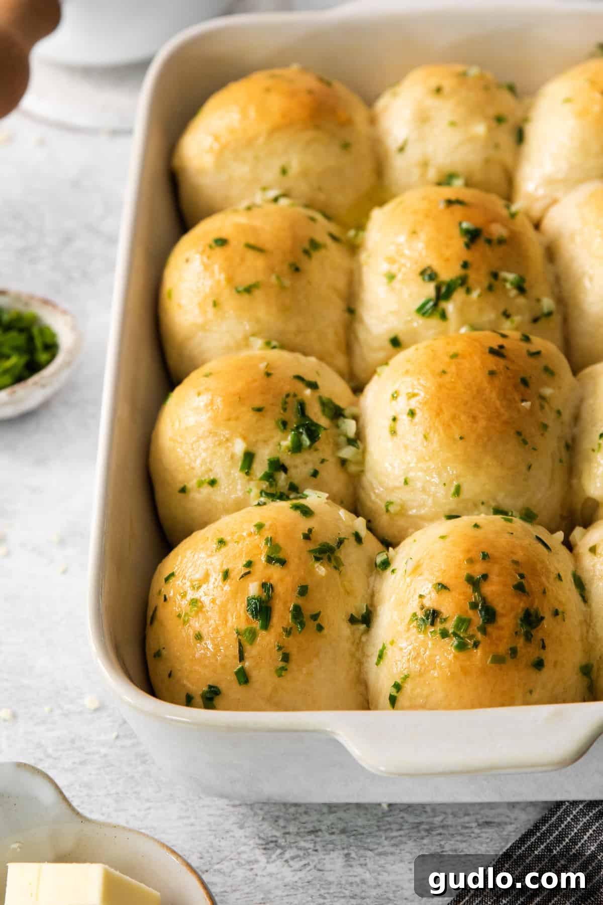 Savory Chive Garlic Cream Cheese Bites 2 Golden brown cheesy garlic rolls arranged perfectly in a baking dish, ready to be served.