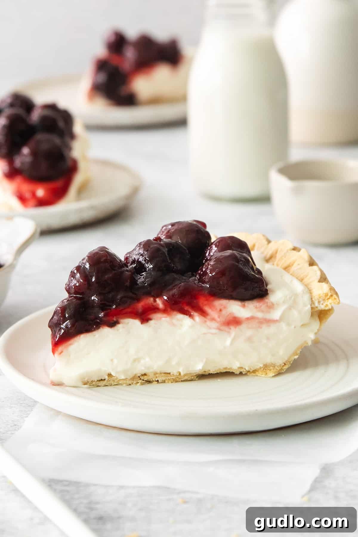 Dreamy Cherry Cream Cheese Pie 2 A beautifully presented slice of cherry cream cheese pie on a white plate, showcasing its creamy filling and vibrant cherry topping.