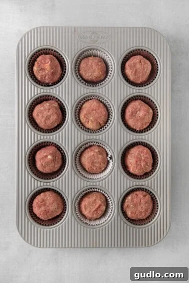 Individual Meatloaf Cups 5 A muffin tin filled with shaped meatloaf balls before baking.