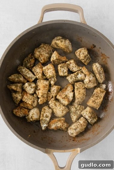 Close-up of golden-brown fried chicken pieces in a cast iron skillet.