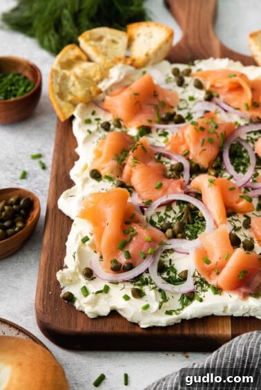 The final cream cheese and smoked salmon board with sliced bagels arranged around it.