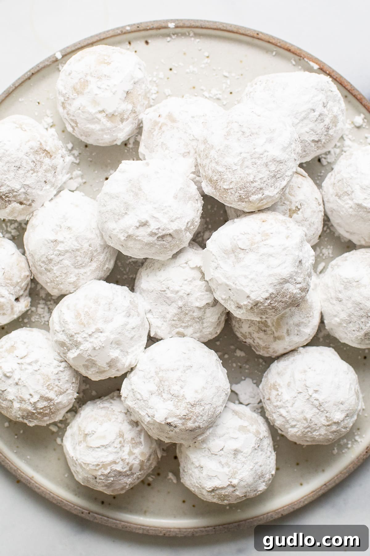 A charming plate of freshly baked powdered sugar snowball cookies, ready to be enjoyed.