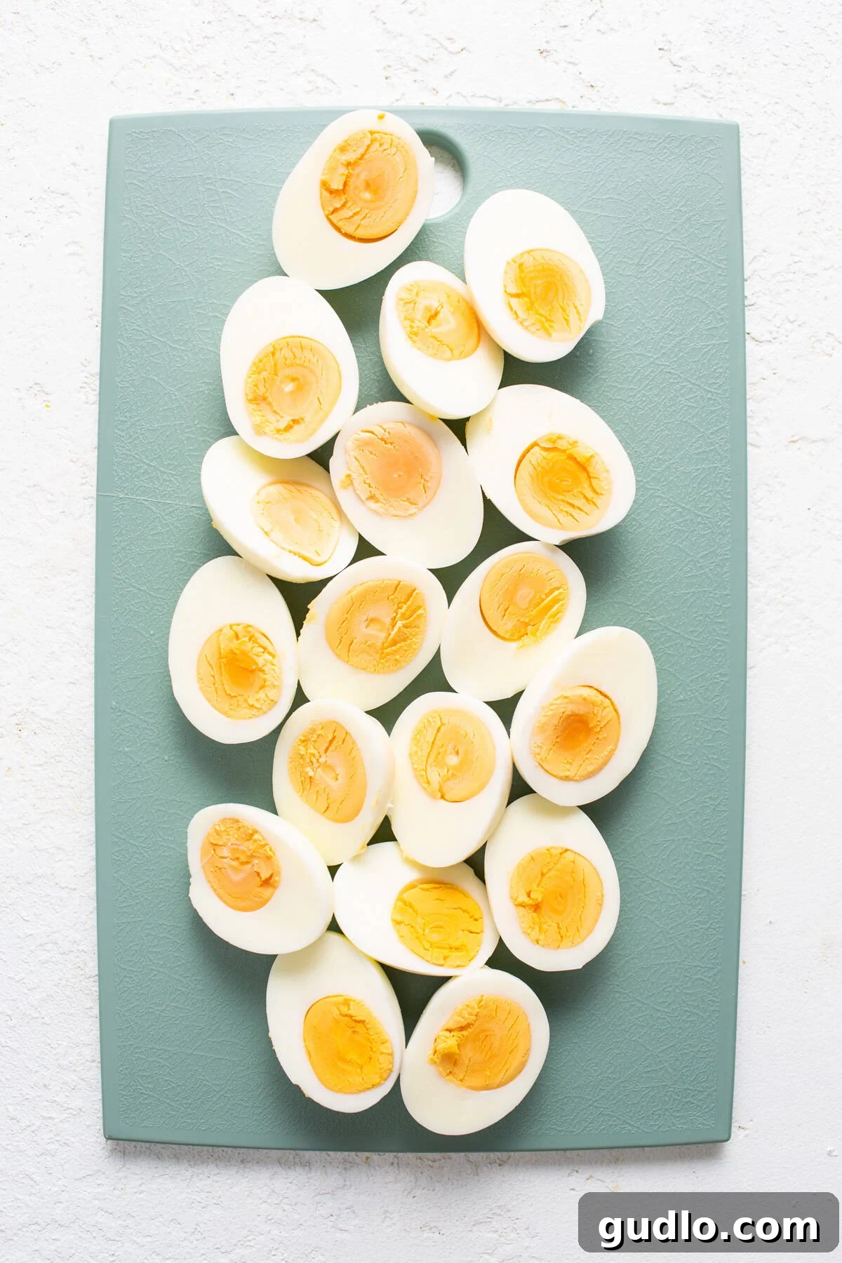 Perfectly hard-boiled eggs, halved and ready to be seasoned, showcasing their rich yolks and serving as a key protein element on the charcuterie board.