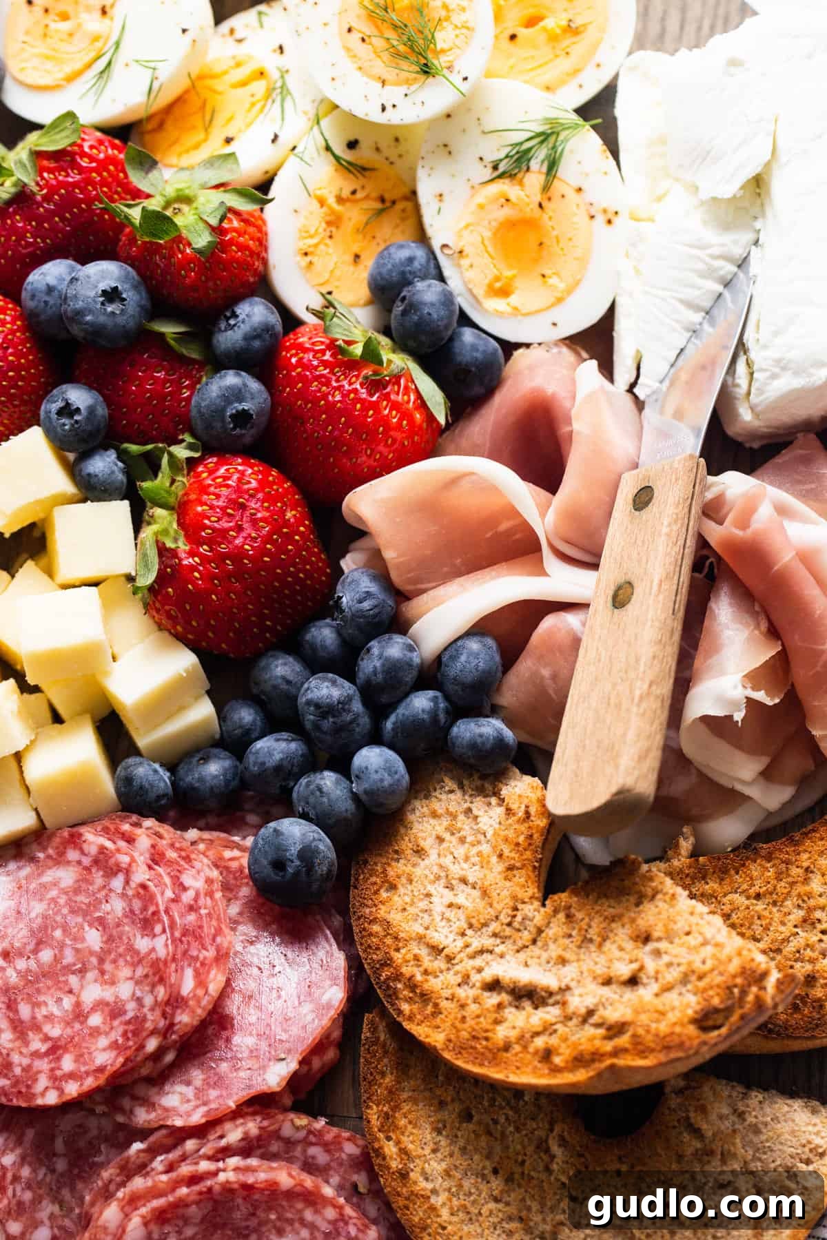 A close-up view of a selection of meats, cheeses, and fruit from a charcuterie board, highlighting the fresh and delicious ingredients.