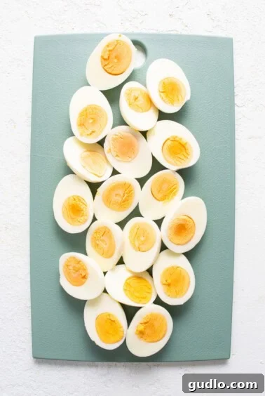 Hard-boiled eggs, perfectly halved, seasoned, and ready for the breakfast charcuterie board, emphasizing fresh preparation.