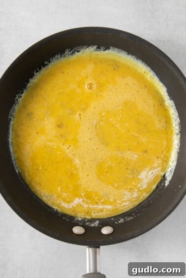 A frying pan with a yellow liquid in it.