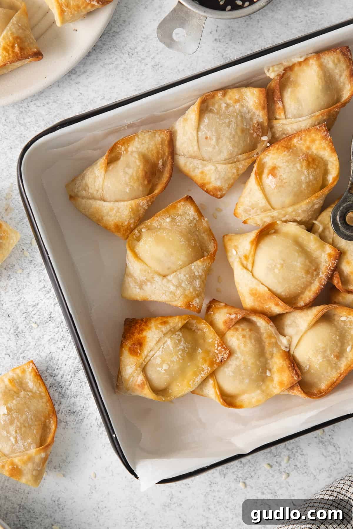 Crispy Air-Fried Crab Rangoons 2 Crispy golden fried dumplings in a baking dish, ready to be served.