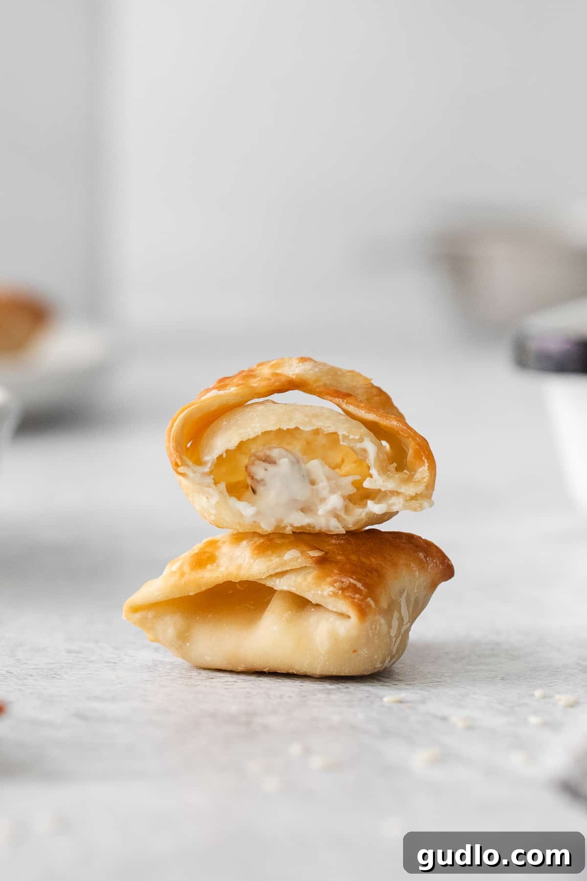 Crispy Air-Fried Crab Rangoons 8 A stack of pastries sitting on a table, showcasing a beautiful food presentation.