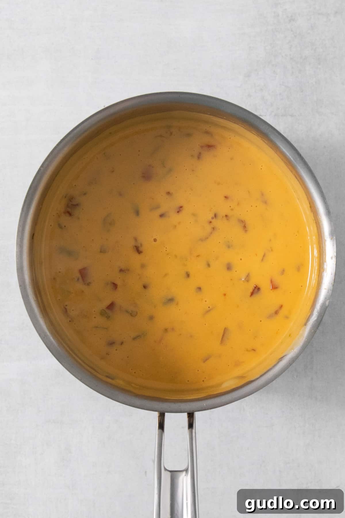 Quick Velveeta Queso: Ready in 15 Minutes 5 A pan full of soup on a white background.