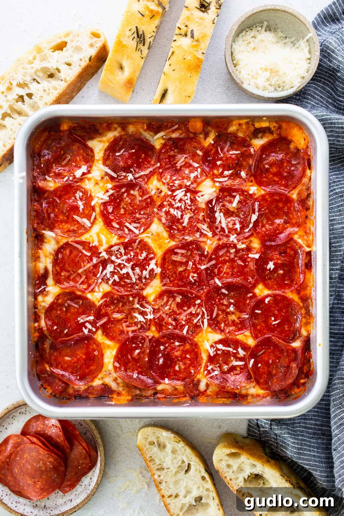 Baked Cheesy Pizza Dip with Toasted Focaccia 2 Pepperoni pizza in a baking dish with freshly baked focaccia bread.