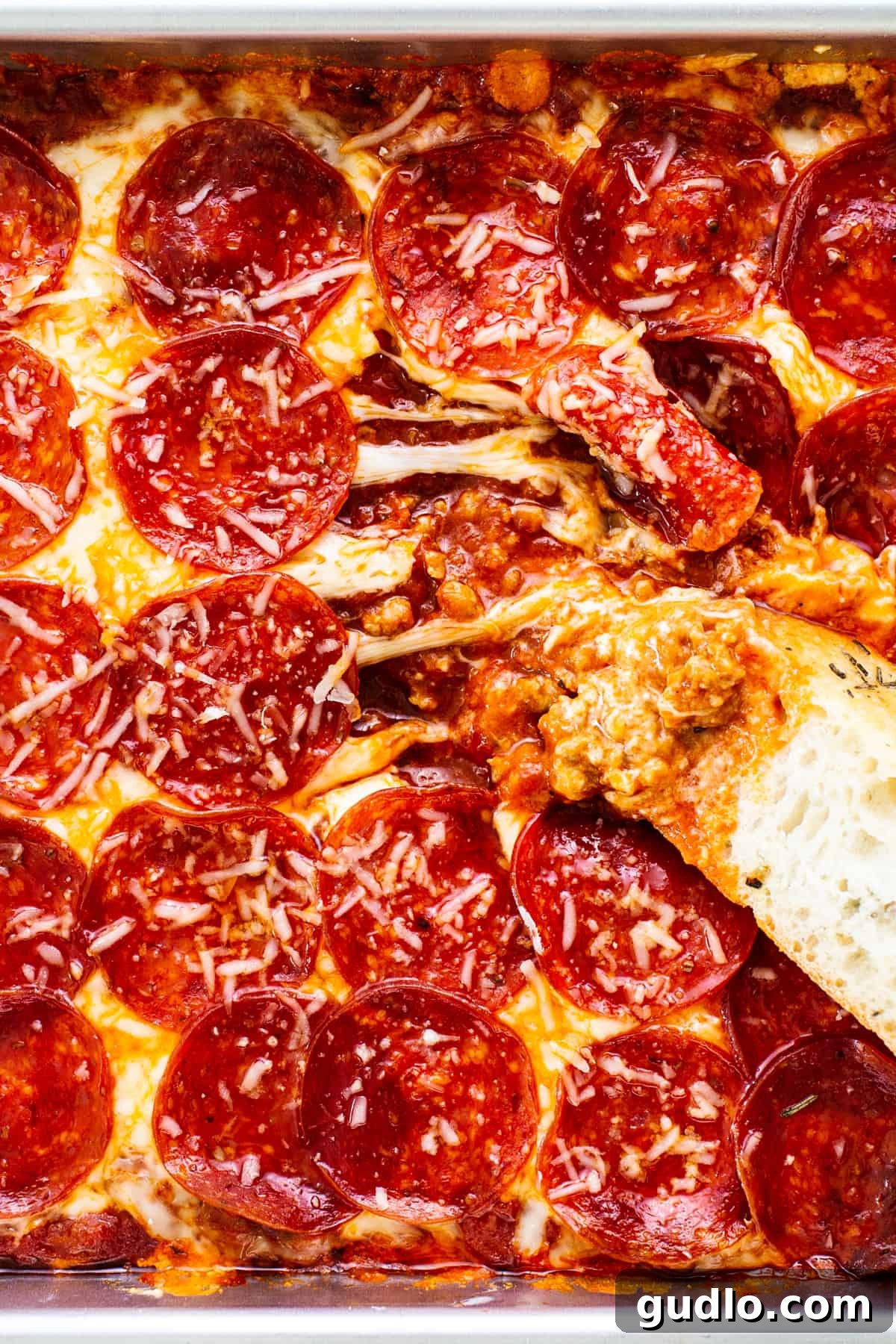 Baked Cheesy Pizza Dip with Toasted Focaccia 5 Sliced pepperoni pizza dip with focaccia bread pieces.
