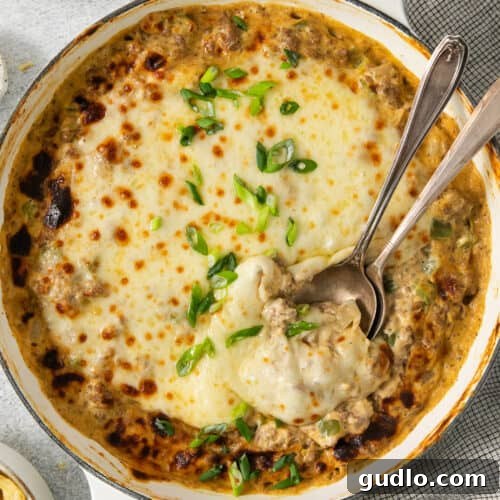 Decadent Philly Cheesesteak Dip 7 A casserole dish with cheese and meat in it.