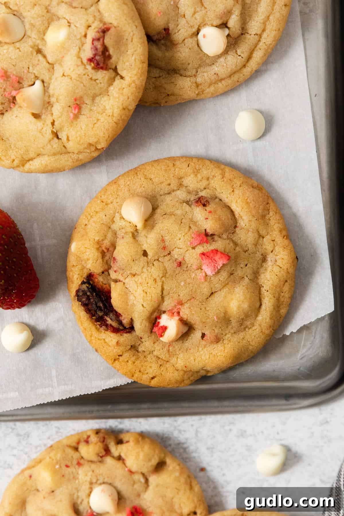 A tray of freshly baked strawberry white chocolate chip cookies cooling.