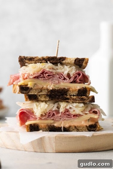 A finished Reuben sandwich, cut in half, showcasing all the delicious layers.