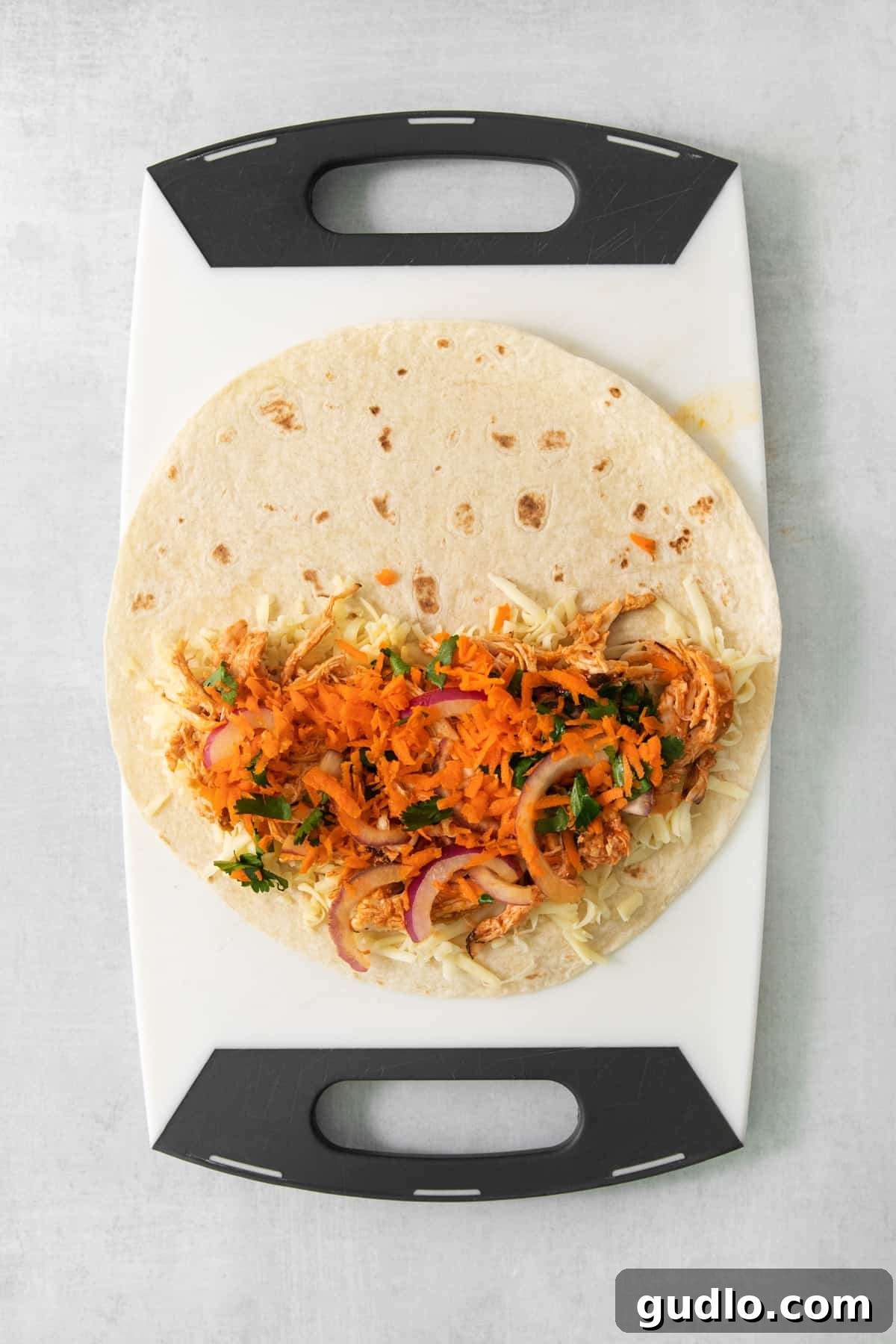 A taco shell on a cutting board, prepared with the vibrant pickled carrots and onions.