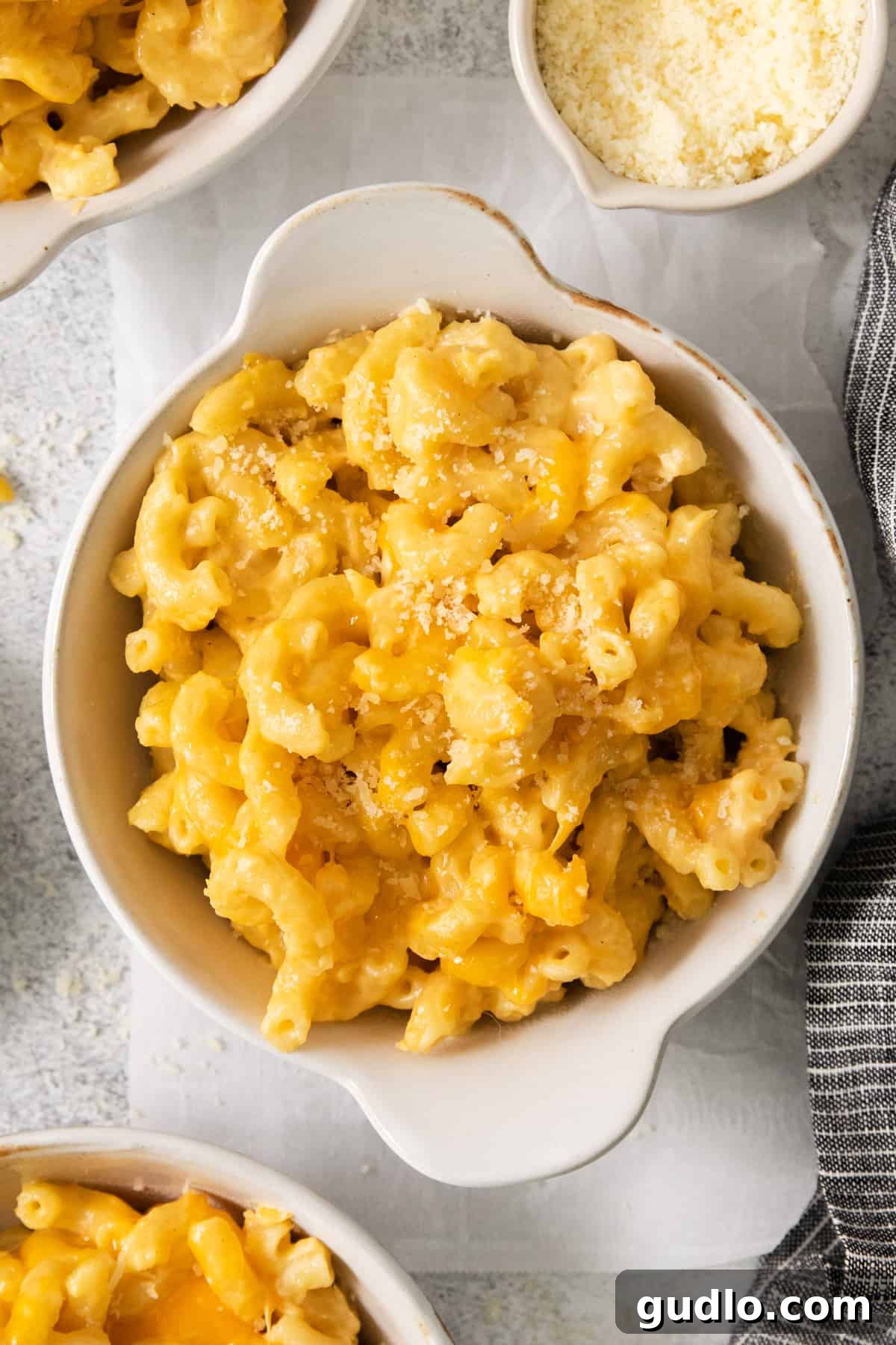 The Ultimate Chick-Fil-A Mac and Cheese Clone 2 Macaroni and cheese in bowls on a gray background, showcasing a rich, creamy texture.