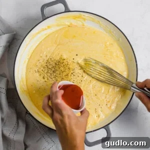 Rustic Tuscan Chicken Mac and Cheese Bake 3 A perfectly creamy mac and cheese sauce, highlighting its simple yet scrumptious composition and smooth texture.